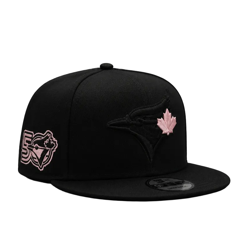 Black cap with pink logo and leaf design on a white background