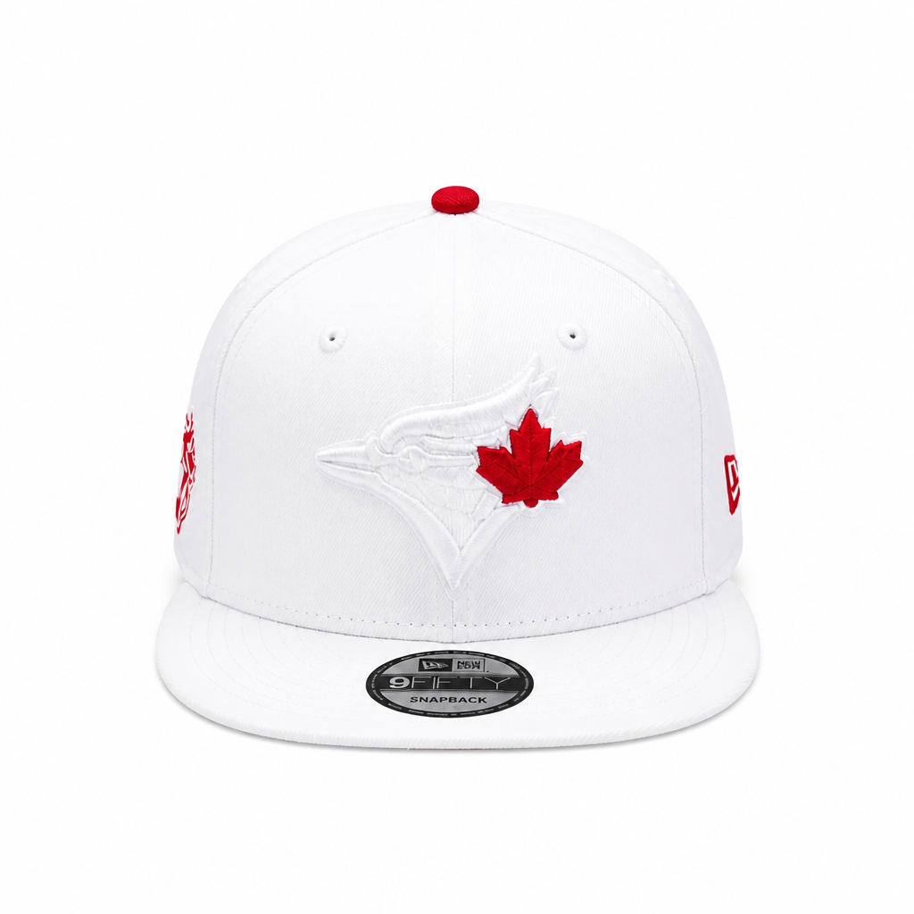 A white Toronto Blue Jays 9FIFTY fitted baseball cap featuring a red maple leaf and white bird logo on the front, with red side embroidery and a red button on top, photographed on a clean white background.