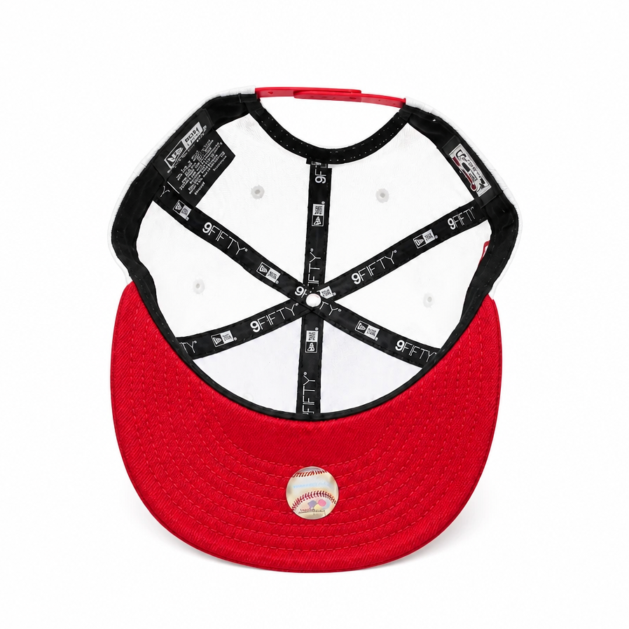 Red baseball cap viewed from the back, showing a white structured back panel with black adjustable straps and a baseball patch on the flat brim, on a white background.