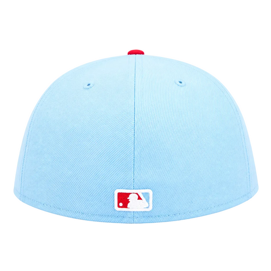 A light blue baseball cap with a red button on top and a white and red MLB logo patch on the front, shown against a plain white background.