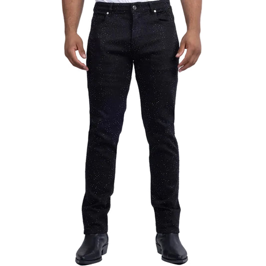 A person wearing slim-fit black jeans with a subtle speckled texture, paired with black boots and a white shirt, shown from the waist down against a light gray studio background.
